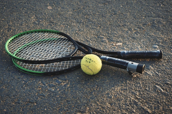 Twee tennisrackets met een tennisbal